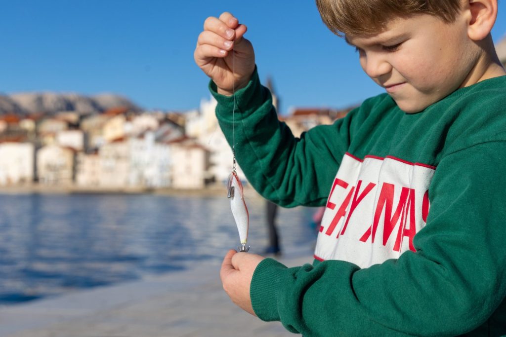 Dječak i peškafondo - tradicionalni pribor za lov na lignje / Foto: TZ Baška